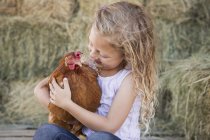 Girl holding chicken — Stock Photo