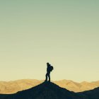 Турист стоит на вершине холма — стоковое фото