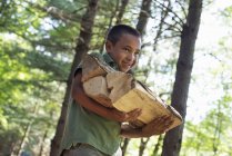 Хлопчик, що носить дрова через ліс . — стокове фото