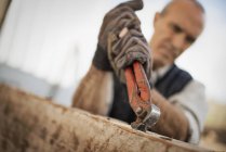 Man working in a reclaimed timber yard. — Stock Photo