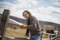 Man fixing post and rail fence — Stock Photo