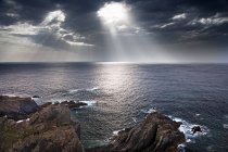 Сонце тече крізь хмару до моря — стокове фото