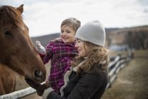 Frau und Mädchen tätscheln Pferd — Stockfoto
