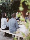 Pessoas em volta de uma mesa em um jardim . — Fotografia de Stock