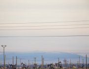 Нефтяные вышки и линии электропередач — стоковое фото