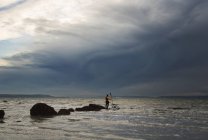 Homme se tient sur un rocher au kayak — Photo de stock