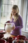 Girl holding a white pottery jug. — Stock Photo