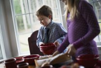 Kinder decken den Tisch mit Geschirr für eine Mahlzeit. — Stockfoto
