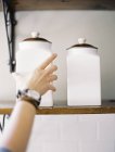 Person reaching up to two storage jars — Stock Photo