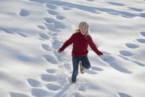 Ragazza che corre attraverso la neve profonda — Foto stock