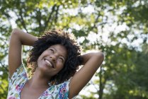 Jovem mulher sorrindo e olhando para cima . — Fotografia de Stock