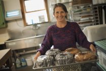 Woman in a kitchen with fresh baked cakes. — Stock Photo