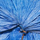 Bâche bleue, rassemblée et attachée — Photo de stock