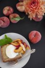 Teller mit Creme fraiche Kuchen und Pfirsichen — Stockfoto