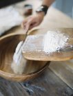 Versando a mano la farina in ciotola — Foto stock
