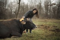Donna che lavora in azienda e si prende cura della mucca — Foto stock