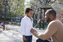 Father buttoning his son's jacket — Stock Photo