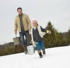 Man and child carrying buckets — Stock Photo