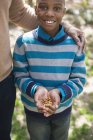 Хлопчик тримає жменьку горіхів . — стокове фото