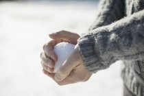 Man holding a large snowball — Stock Photo