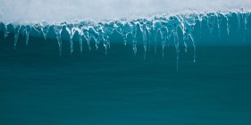 Icicles colgando de iceberg - foto de stock