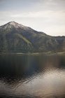 Pico de la montaña que se eleva sobre un lago - foto de stock