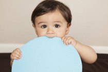 Baby boy chewing large disc — Stock Photo