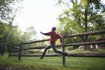Garçon courir autour d'un paddock — Photo de stock