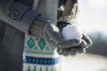 Женщина, держащая небольшой снежный ком — стоковое фото