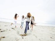 Mujeres corriendo en una playa - foto de stock
