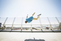 Man somersaulting on a bridge. — Stock Photo