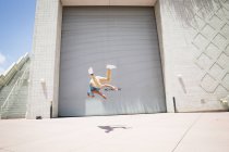 Homme sautant devant une porte de garage . — Photo de stock