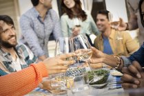 People laughing and clinking wine glasses — Stock Photo