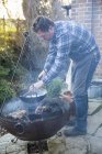 Uomo che cucina verdure in una padella — Foto stock