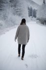 Mulher andando em um caminho nevado . — Fotografia de Stock