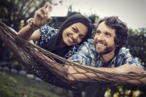 Man and woman lying in a large hammock — Stock Photo