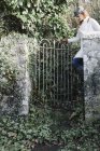 Donna che apre un cancello del giardino — Foto stock