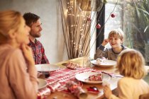 Familie sitzt zur Weihnachtszeit am Tisch — Stockfoto