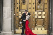 Paar küsst sich auf den Stufen eines Gebäudes. — Stockfoto