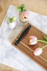 Tabla de madera con mango con tulipanes - foto de stock
