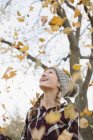 Teenager-Mädchen wirft Herbstblätter — Stockfoto