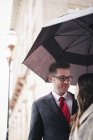 Lovers in the city under an umbrella. — Stock Photo