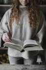 Женщина читает из книги рецептов — стоковое фото