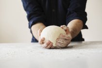 Baker shaping dough into a ball. — Stock Photo