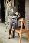Woman cleaning and preparing tack and saddle — Stock Photo