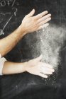 Baker dusting his hands with flour. — Stock Photo