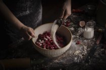 Woman adding sugar in fresh raspberries — Stock Photo