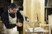 Чоловік працює на дерев'яному стільці . — стокове фото