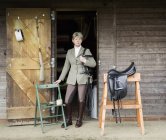 Woman standing near enter of riding stable — Stock Photo