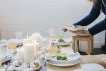 Жінка розміщує тарілку їжі на столі — стокове фото